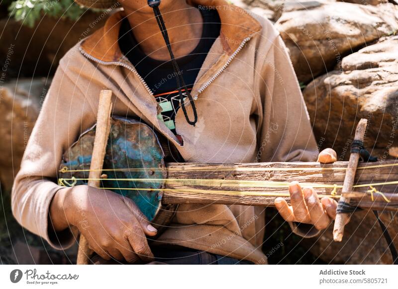 Traditional African musician playing a stringed instrument africa traditional culture close-up hands performance homemade indigenous artisan craftsmanship