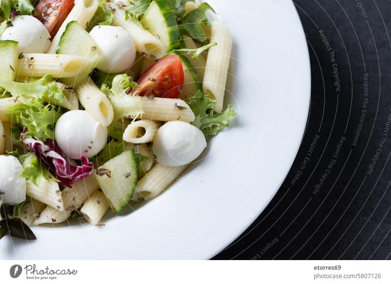 Pasta salad with vegetables and mozzarella cheese on black background cucumber dish healthy ingredient lettuce macaroni meal mozzarella ball nutrition pasta