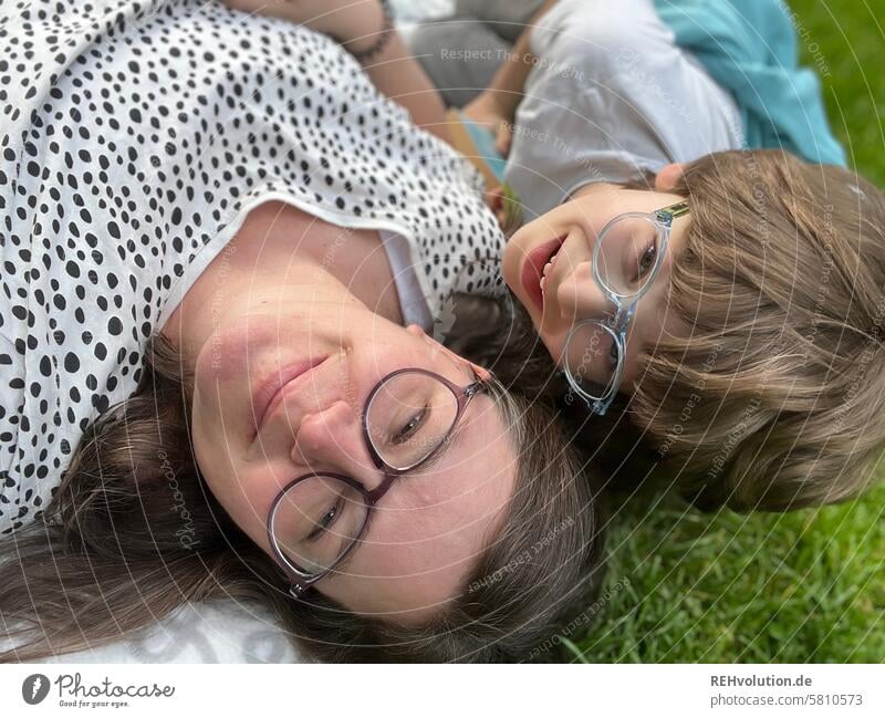 Mother lying in the meadow with her son Woman Child Son Together Family & Relations relation Love Infancy portrait Day naturally Joy Smiling Human being