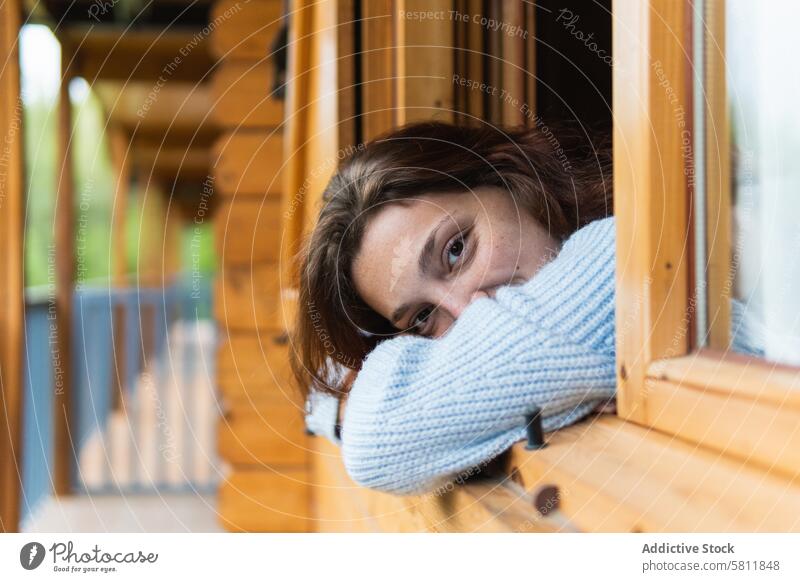 Serene woman relaxing on terrace of house in countryside chill vacation window travel traveler serene peaceful enjoy female pyrenees calm wooden idyllic harmony