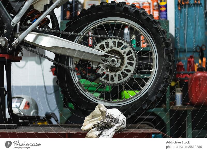 Retro motorbike on platform lift in workshop motorcycle wheel maintenance garage vehicle vintage service mechanic repair retro dirty chrome detail tyre steel