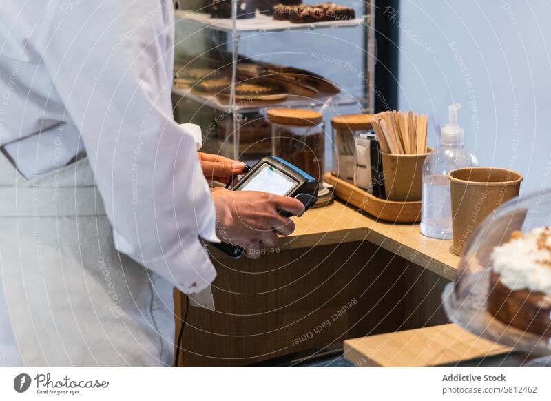 Crop seller using payment terminal in bakery pos transaction counter bakehouse purchase retail contactless vegan dessert commerce money service store transfer
