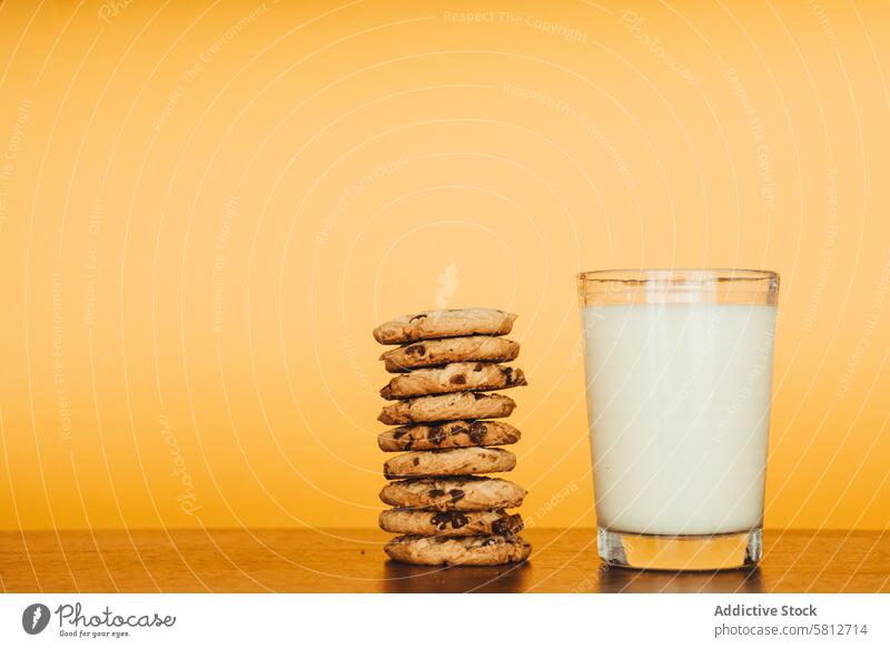 Delicious Breakfast: Cookies and Milk on a Wooden Table with an Orange Background. breakfast photography food styling cookie and milk images