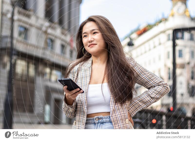 Young Asian Woman Walking and Using Smartphone in the City asian people street city young happy lifestyle walking fun outdoors women urban female cheerful