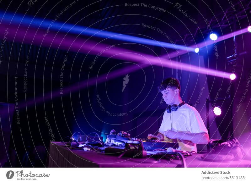 Concentrated DJ performing on a night club copy space dj man youth caucasian disco work light neon lifestyles entertainment arts touch