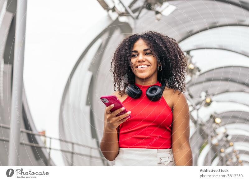 Portrait of a girl with afro hair enjoying in the city using smartphone African American Summer Youth Communication Joy Laughter Happiness Leisure Relaxation