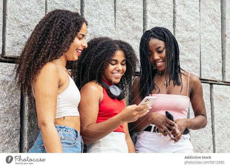 Connected young people: female friends using smartphone in the city African American Summer Friends Diversity Youth Communication Joy Laughter Happiness Leisure