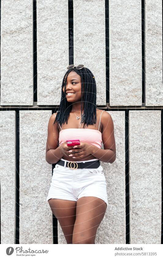 Portrait of a black young woman enjoying in the city using smartphone African American Summer Youth Communication Joy Laughter Happiness Leisure Relaxation