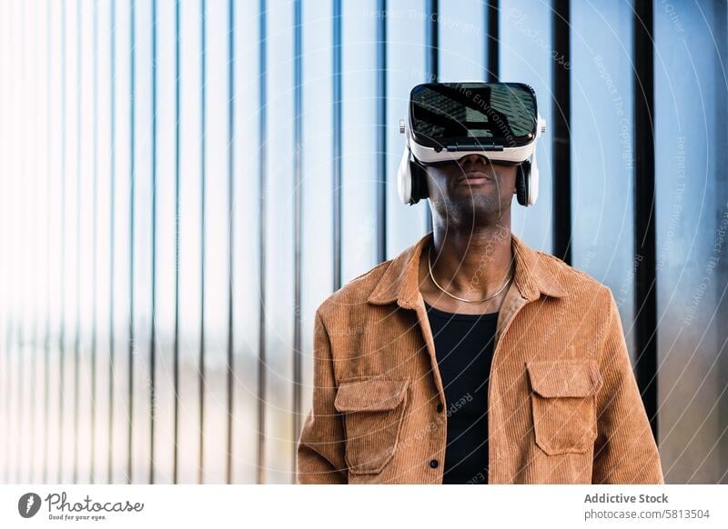 Black man exploring virtual reality in VR headset vr goggles city explore cyberspace futuristic building simulator modern african american black male experience