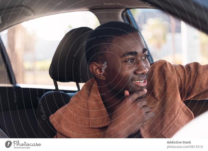 Cheerful black man in car driver automobile smile commute appearance window street steering wheel positive african american transport modern city trendy glad