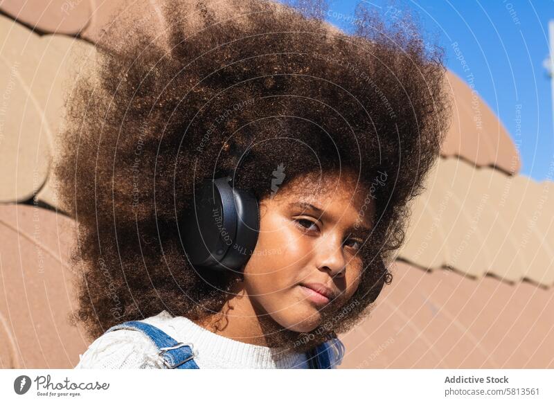 African American girl listening to music with headphones afro teen hipster wireless kid curly hair black african american ethnic female teenage device gadget