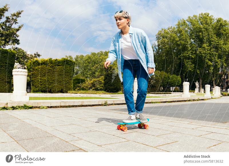 teenager stylish girl skating on a city square. side view fun skateboard skater cool beautiful young trendy lifestyle woman fashion female casual happy urban