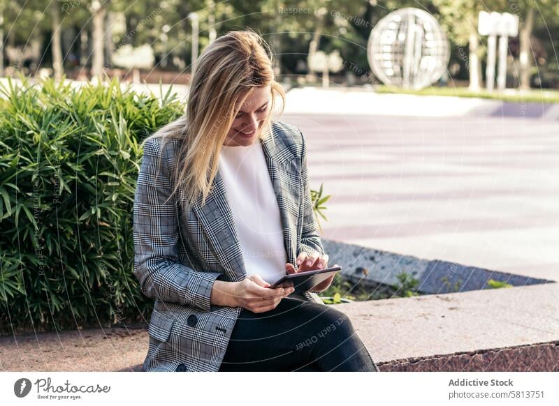 blonde business woman in a suit using a tablet outside and smiling meeting team professional executive success entrepreneur finance businesswoman corporate