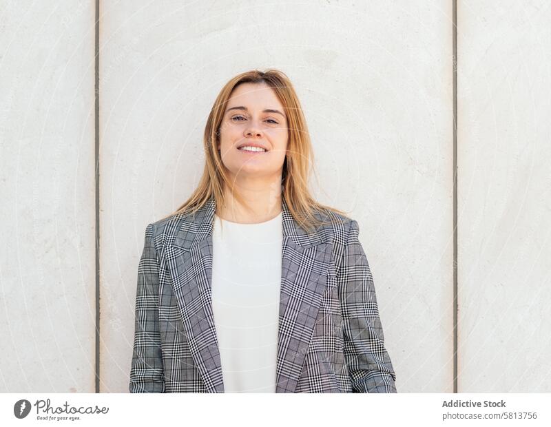 Portrait of a blonde businesswoman in a suit posing and looking at camera with confidence professional executive success entrepreneur finance corporate