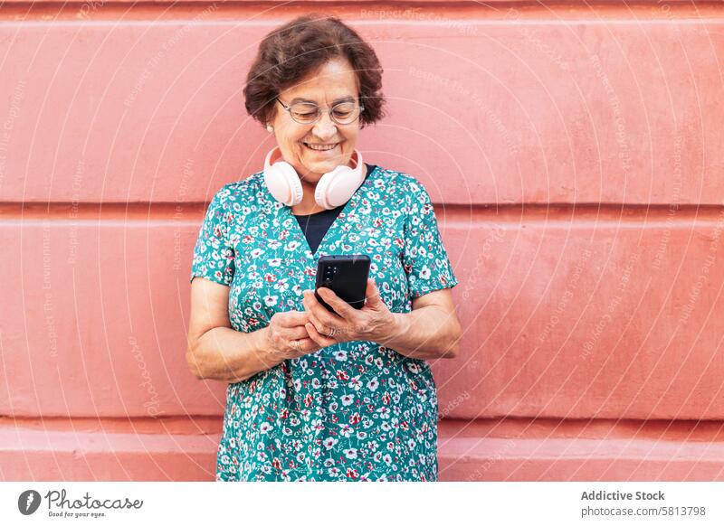 Smiling old woman using smartphone outdoors stylish mobile cellphone senior female communication device message lifestyle internet mobile phone people