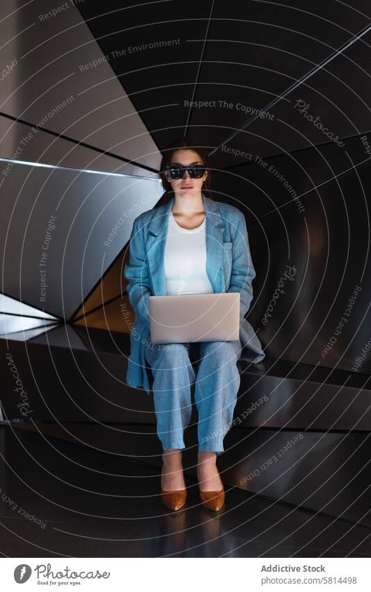 Woman in sunglasses browsing laptop in studio woman futuristic 3d modern design online internet gadget using device elegant female wall connection style