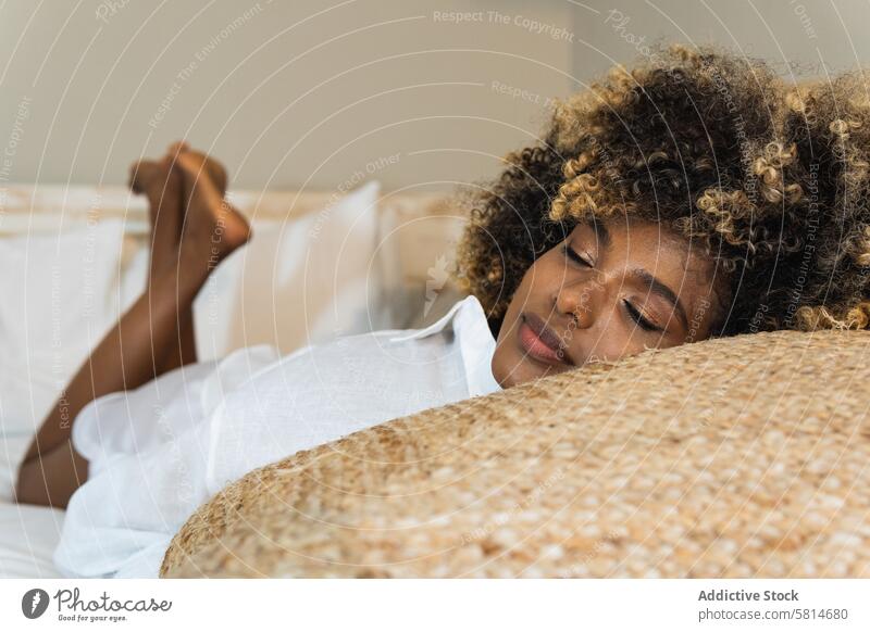 Black woman having nap on bed rest sleep lazy morning early relax home female eyes closed lying tranquil bedroom hairstyle comfort flat peaceful chill hairdo