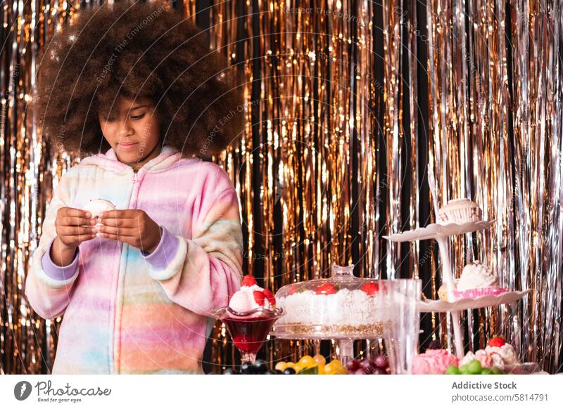 Cute black girl with donut in room with tinsel stripes confectionery sweet dessert treat candy golden festive ethnic african american afro hairstyle holiday