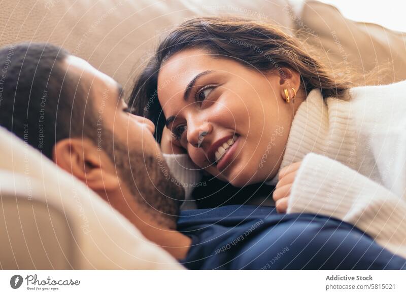 Romantic stock photo of young couple on sofa at home romance love cozy intimate relationship together happiness comfort togetherness affection bonding