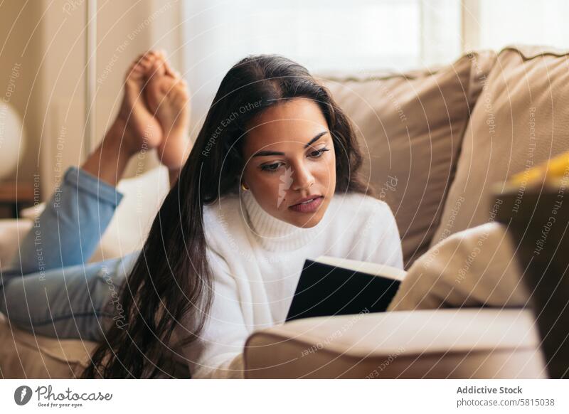 Relaxing at Home: Young Woman Reading a Book on the Sofa Relaxation Tranquility Comfort Serenity Contentment Leisure Cozy Lifestyle Peaceful Pleasant Enjoyment