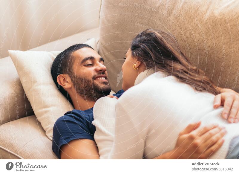 Romantic stock photo of young couple on sofa at home romance love cozy intimate relationship together happiness comfort togetherness affection bonding