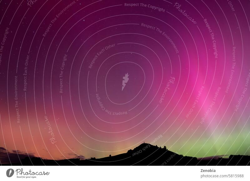 Aurora Australis over Puketapu mountain in Palmerston, Otago. Palmerston is located in the South Island of New Zealand, where the southern lights can sometimes be seen.