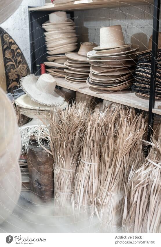 Some palm tree fiber stacks in a hat workshop natural fiber warehouse craft block millinery tailor process production manufacture design fashion material hay