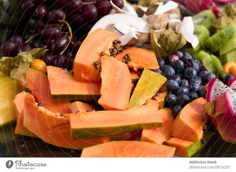 assorted exotic fruits pumpkin kiwifruit grapes coconut raspberries fresh food healthy ripe orange diet organic vegetarian papaya nature slice background sweet