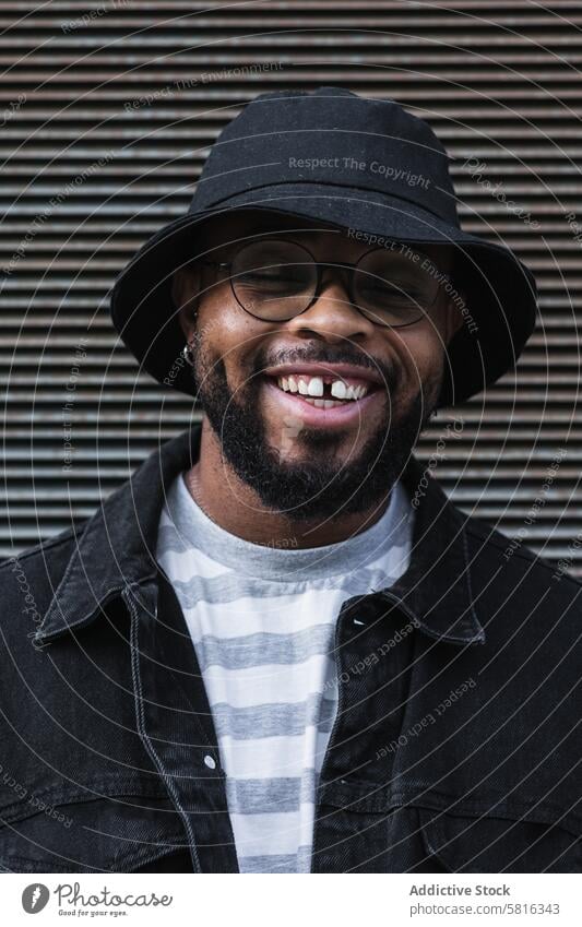 Smiling black hipster man in hat looking at camera happy trendy cheerful smile beard eyeglasses optimist male african american ethnic outfit style positive joy