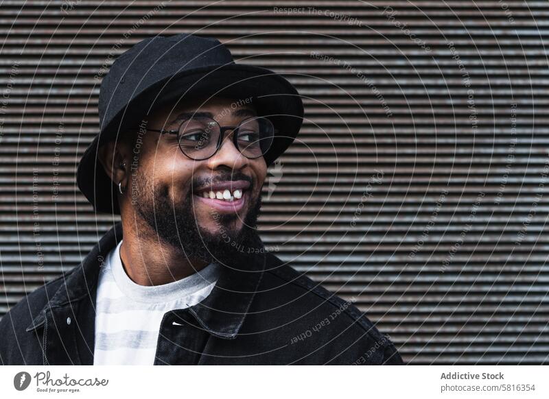 Smiling black hipster man in hat looking away happy trendy cheerful smile beard eyeglasses optimist male african american ethnic outfit style positive joy