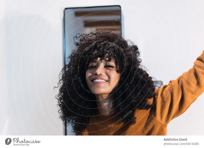 Smiling black woman with curly hair appearance mirror individuality personality afro style sweater charming portrait beauty female african american woman