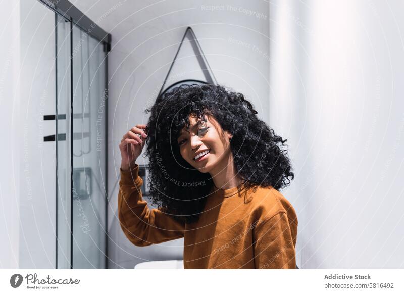 Smiling black woman with curly hair appearance mirror individuality personality afro style sweater charming portrait beauty female african american woman