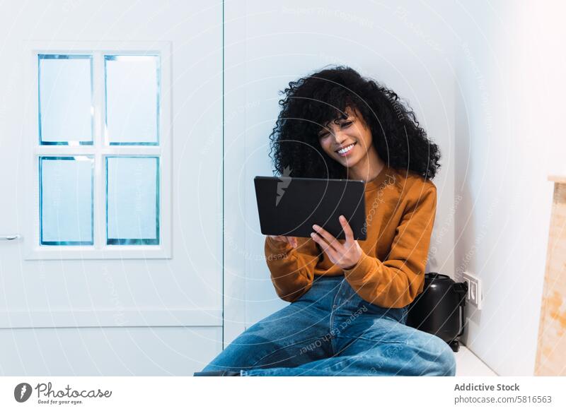 Black woman with tablet on counter using kitchen online chill at home free time relax internet female portrait black african american browsing gadget young