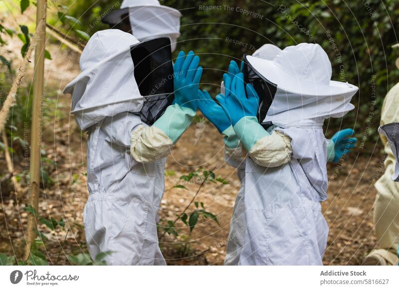 Faceless group of children in protective uniform in apiary costume together kid garden countryside safety glove rubber meadow village gather apiculture nature