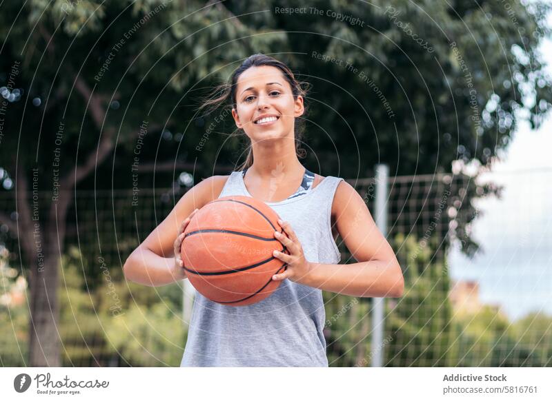 Portrait of Female Basketball Player Holding Ball basketball sport young game court lifestyle player urban outdoor athletic active playing leisure sportsmanship