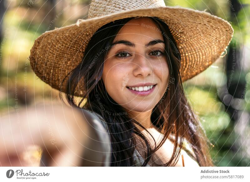 Portrait of a woman with a straw hat in the forest female young nature park lifestyle walk leisure outdoors sunny tree caucasian holiday happiness green natural
