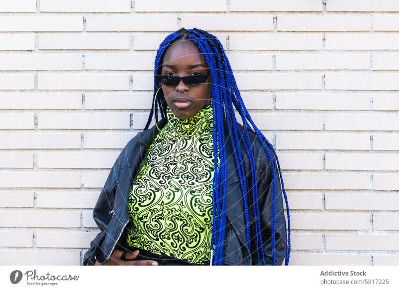 Determined black woman in trendy clothes in city vivid outfit blue hair braid hairstyle determine appearance female ethnic african american street sunglasses