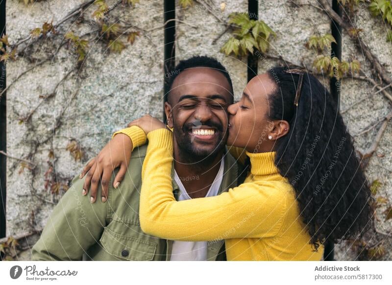 cute afro american couple kissing on the cheek and smiling love happy relationship man woman young together black romantic romance lifestyle beautiful female