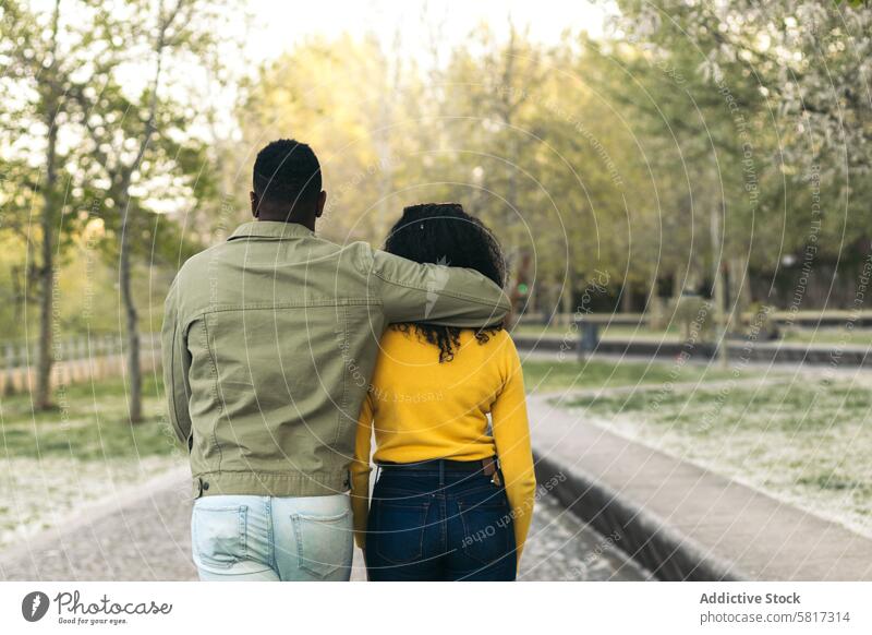 back view of a afro american couple walking in a park female love together man boyfriend woman people lifestyle girlfriend romantic relationship outdoor romance