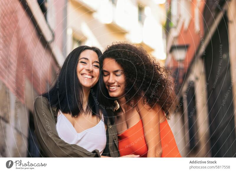 two young women going down street stairs smiling holding her hands and hugging woman happy beautiful female people girl caucasian lifestyle together city couple