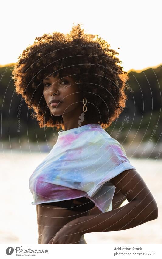 Unemotional black woman standing on seashore bikini summer holiday crop top vacation female ethnic african american panties curly hair afro hairstyle relax
