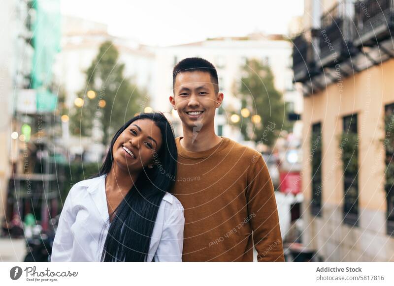 Portrait of a happy interracial couple outdoors asian hispanic woman relationship love together people latina dating lifestyle bonding togetherness girlfriend