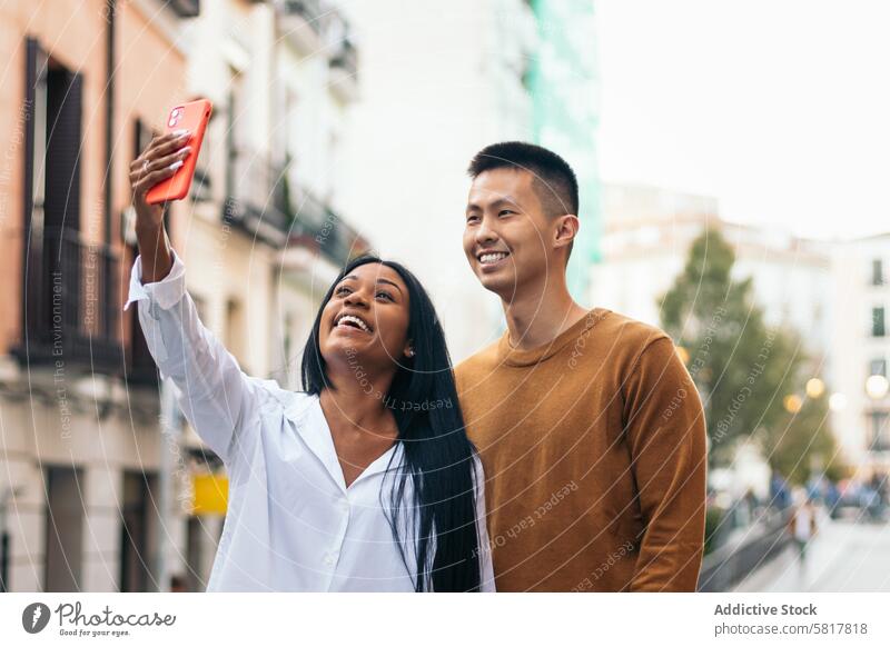 Asian man and latin american woman taking a selfie with smartphone asian hispanic relationship love together people couple latina dating lifestyle bonding