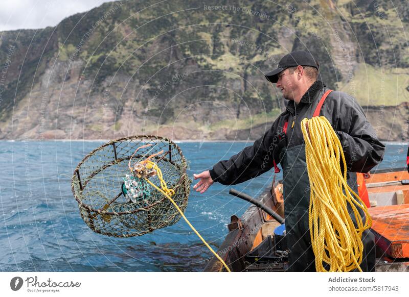 Fisherman collecting lobster fishing nets fisherman collector boat stand caucasian adult apron sea food water day sailor people lifestyles fisher - role