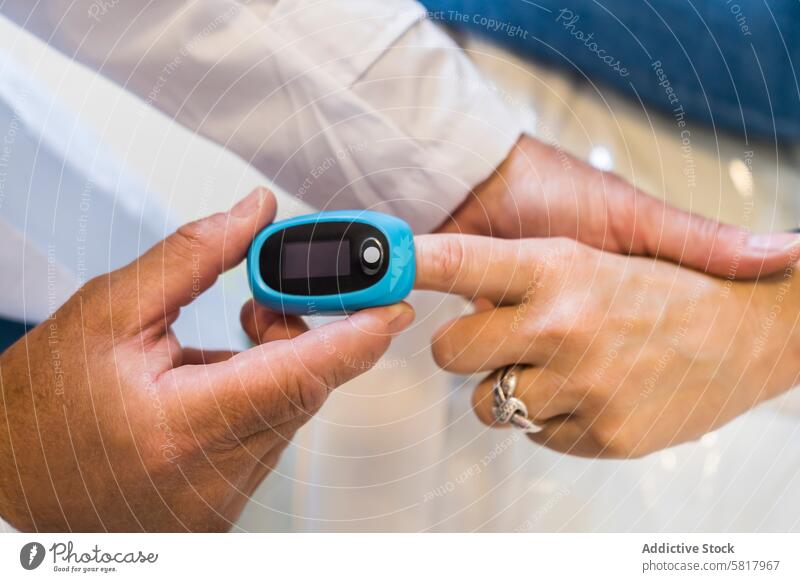 Doctor is putting a pulse oximeter in his patient's hand for measuring oxygen saturation in blood and heart rate. Analyzing Healthcare And Medicine Occupation