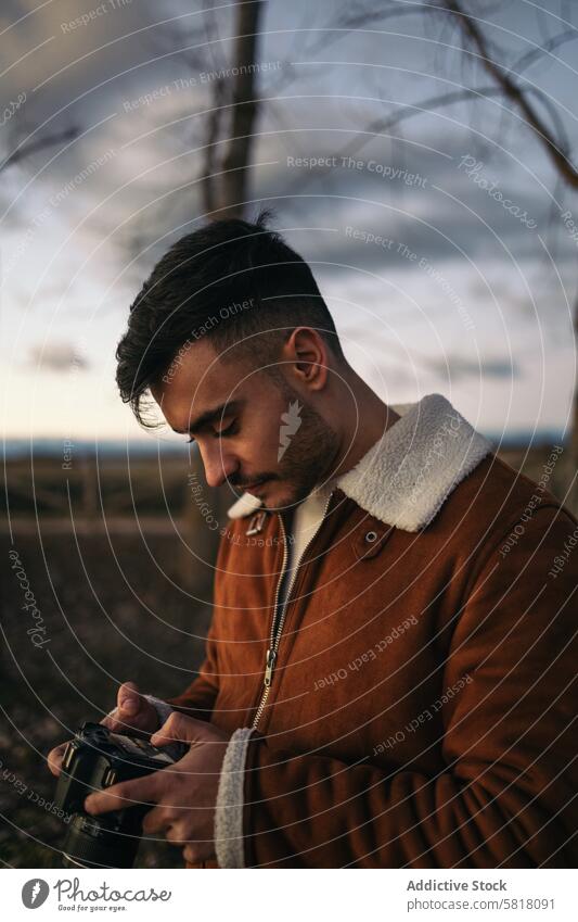 Portrait of a photographer taking photos in the countryside camera photography nature natural light outdoors lifestyle winter sky jacket alone travel calm