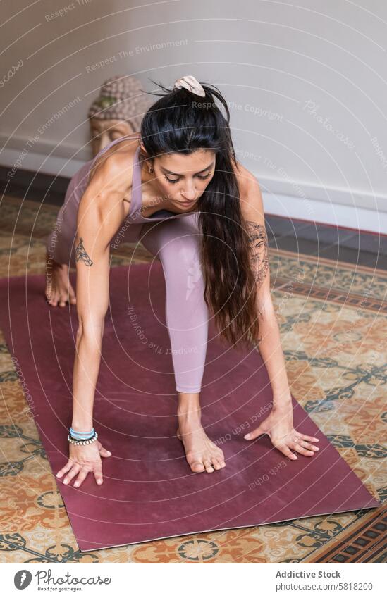 Woman performing Low Lunge pose on yoga mat woman stretch talent wellness vitality ethnic balance home practice flexible healthy lifestyle idyllic Anjaneyasana