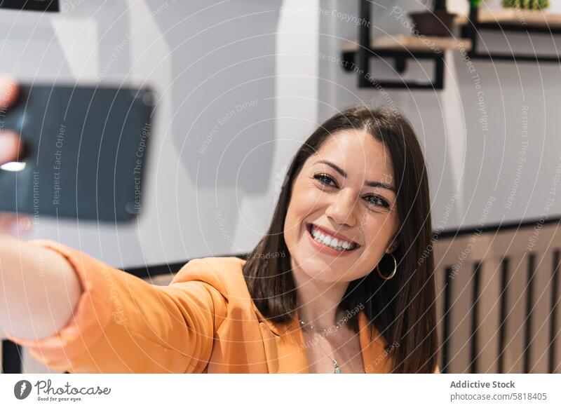 Cheerful woman taking selfie on smartphone in cafe chill having fun smile self portrait mobile female using positive gadget cheerful relax memory moment