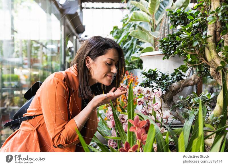 Cheerful woman choosing flowers in garden center market choose bloom pick customer city female plant fresh organic gardener aroma grow growth potted flowerpot