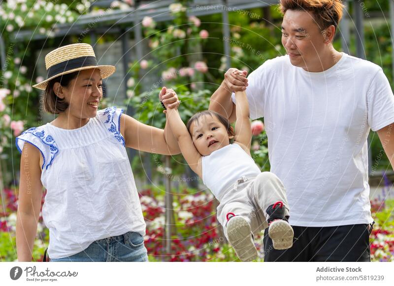 Asian Family Enjoying a Playful Moment on European Vacation asian family vacation europe garden playful child parents togetherness travel leisure outdoor